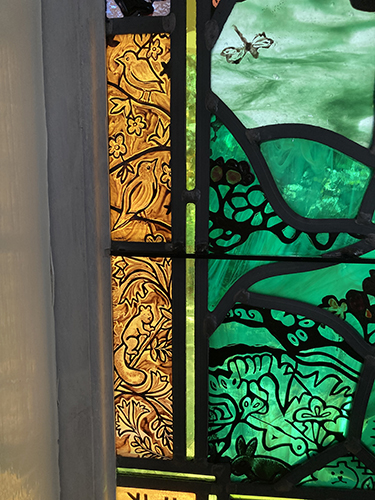 red rocks stained glass birds, squirrel and greenery
